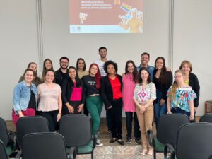 Fotografia das(os) participantes do encontro em Andradas. Todas(os) estão de pé, lado a lado